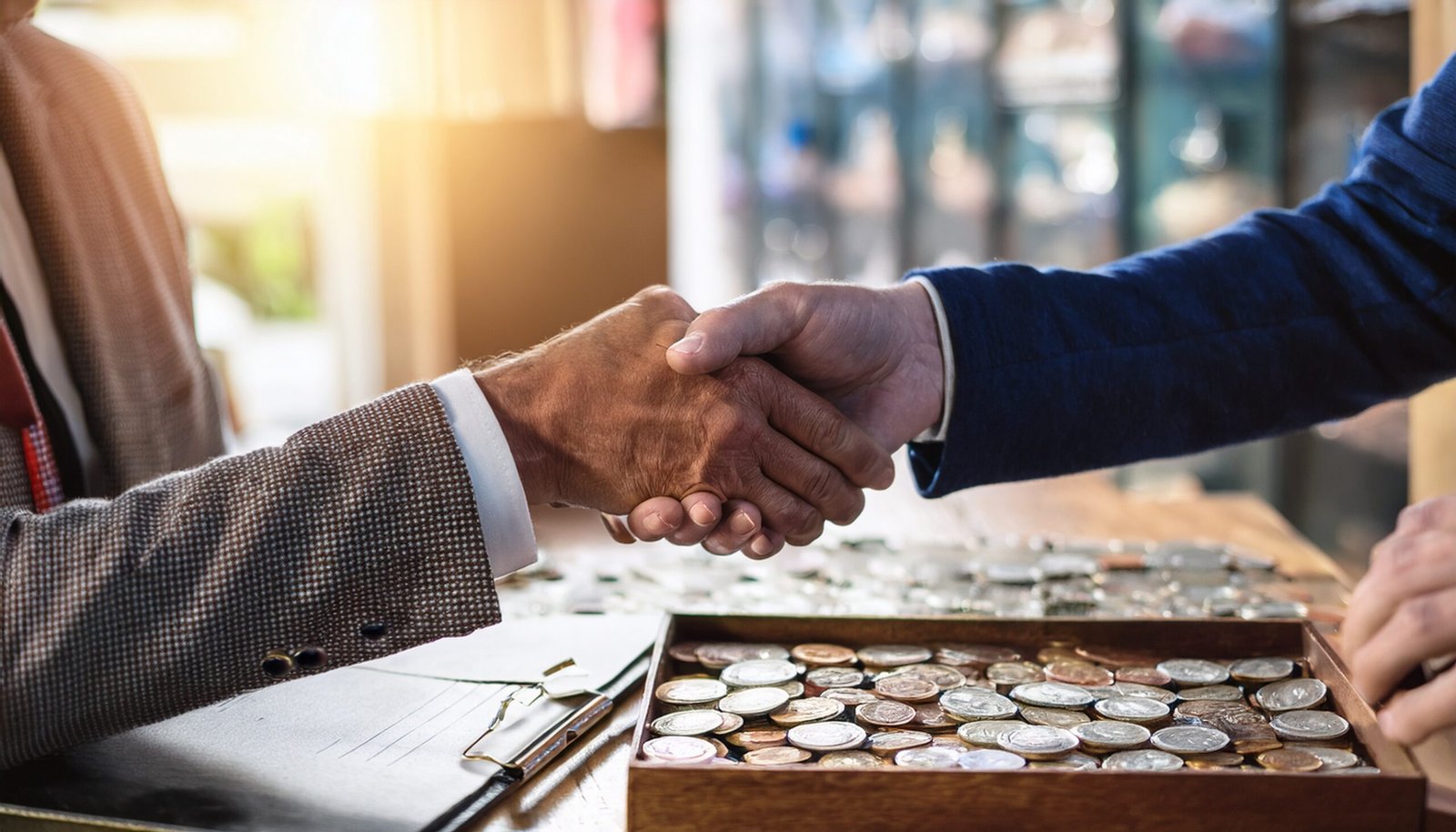 Firefly A buyer and seller shaking hands over a display of collectible coins, trust and professional